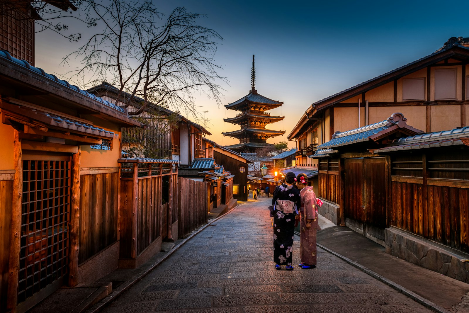 Una calle tradicional de Kioto al atardecer, con una pagoda al fondo
